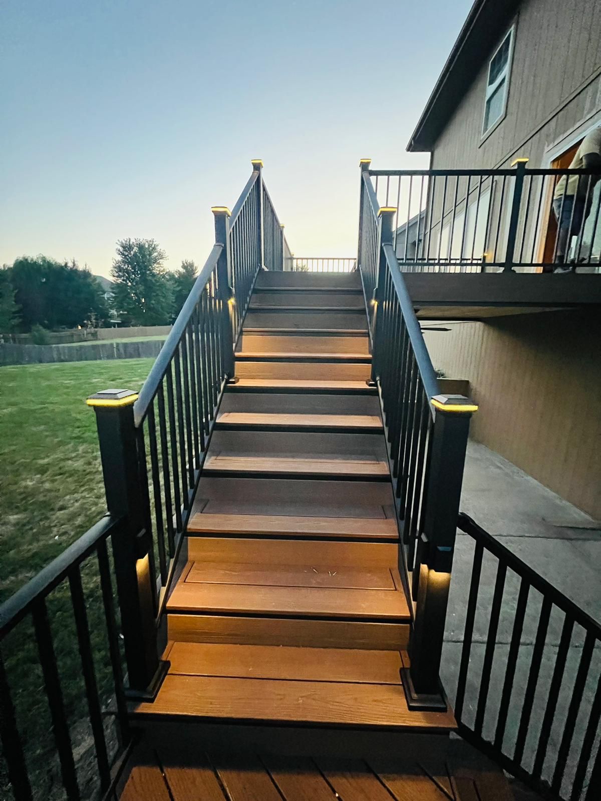 Long composite stair run with black railing and integrated stair lighting