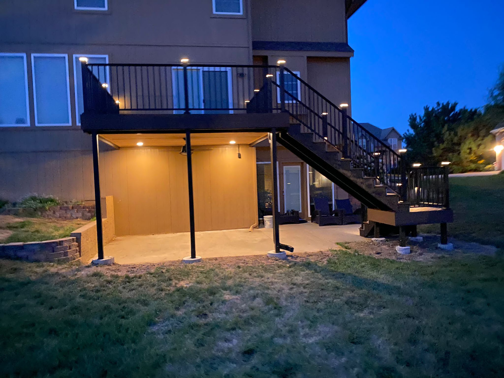 Elevated deck lit at night with post lights and stair lighting