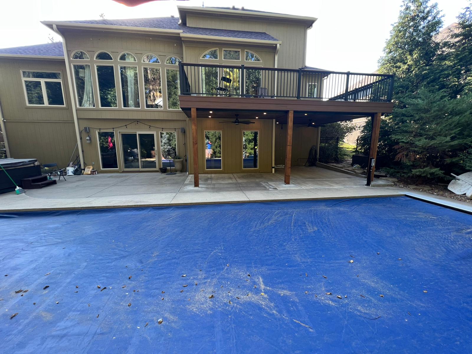 Poolside covered patio under a second-story composite deck