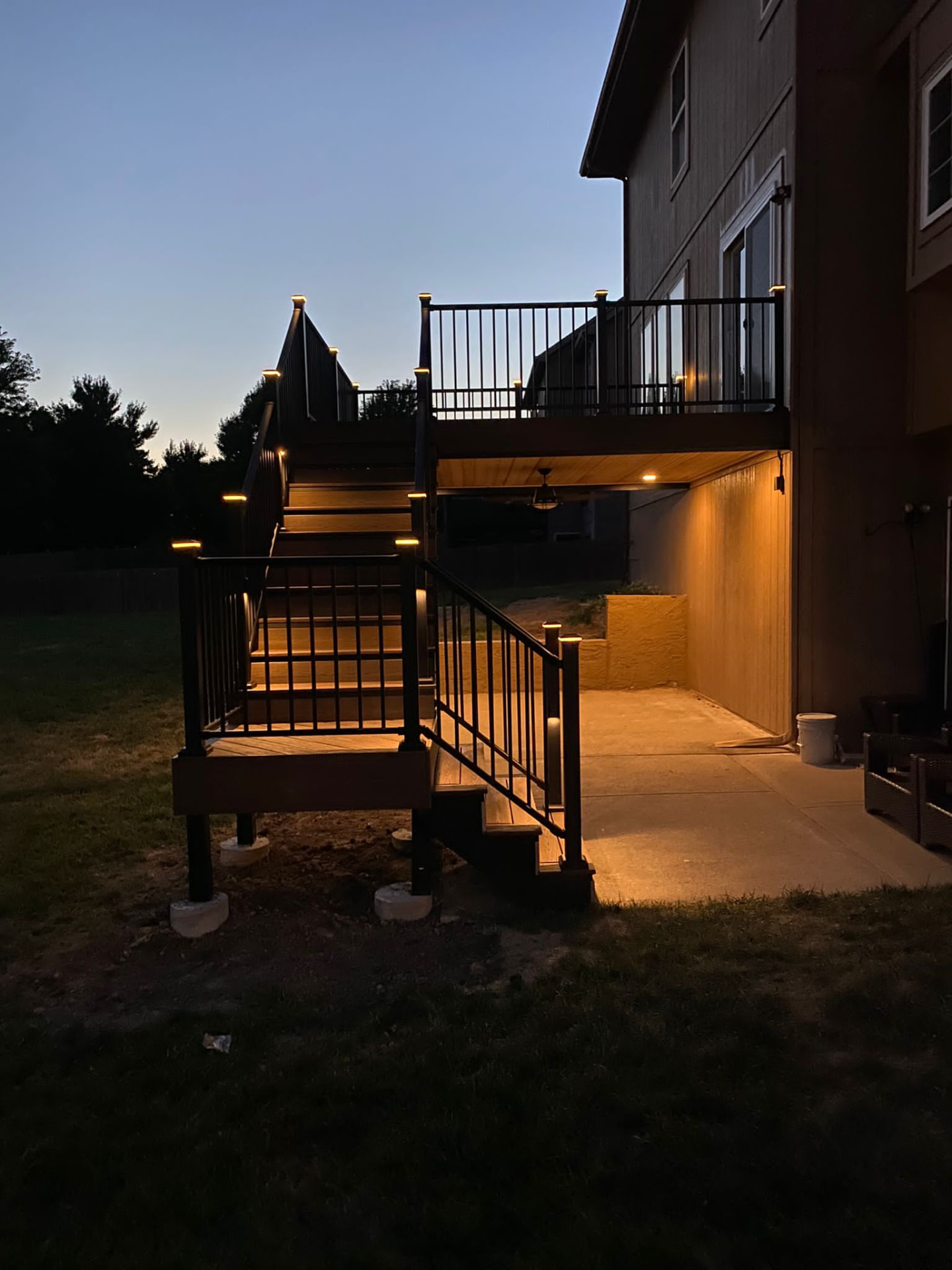 Elevated deck at dusk with lit stairs and under-deck cedar ceiling
