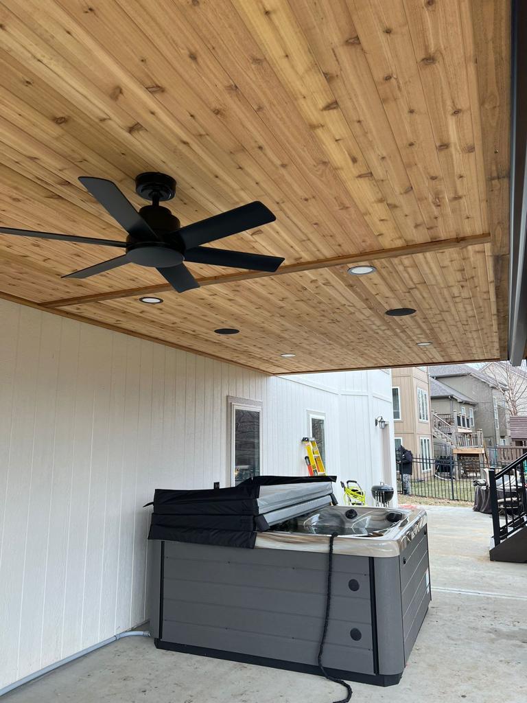 Covered outdoor living area with cedar ceiling and ceiling fan