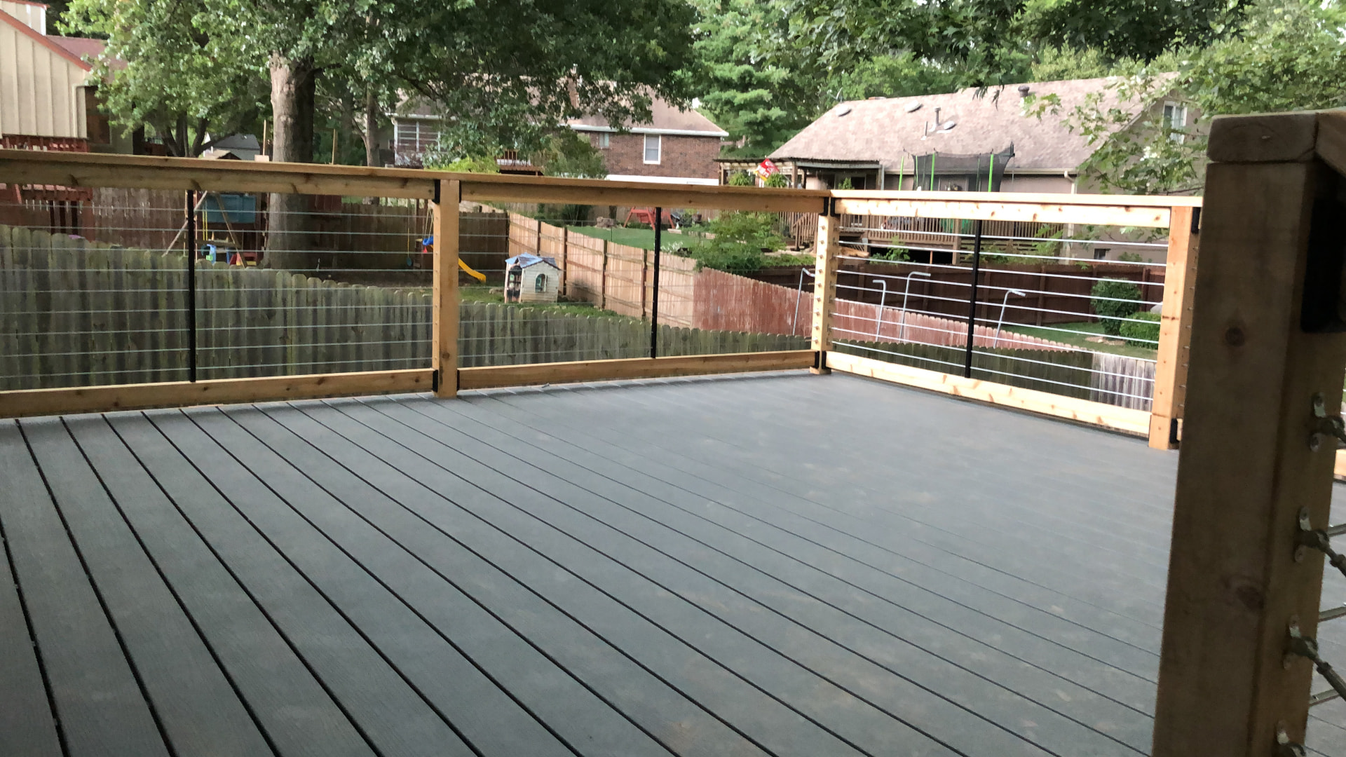 Gray composite deck with cedar and cable railing