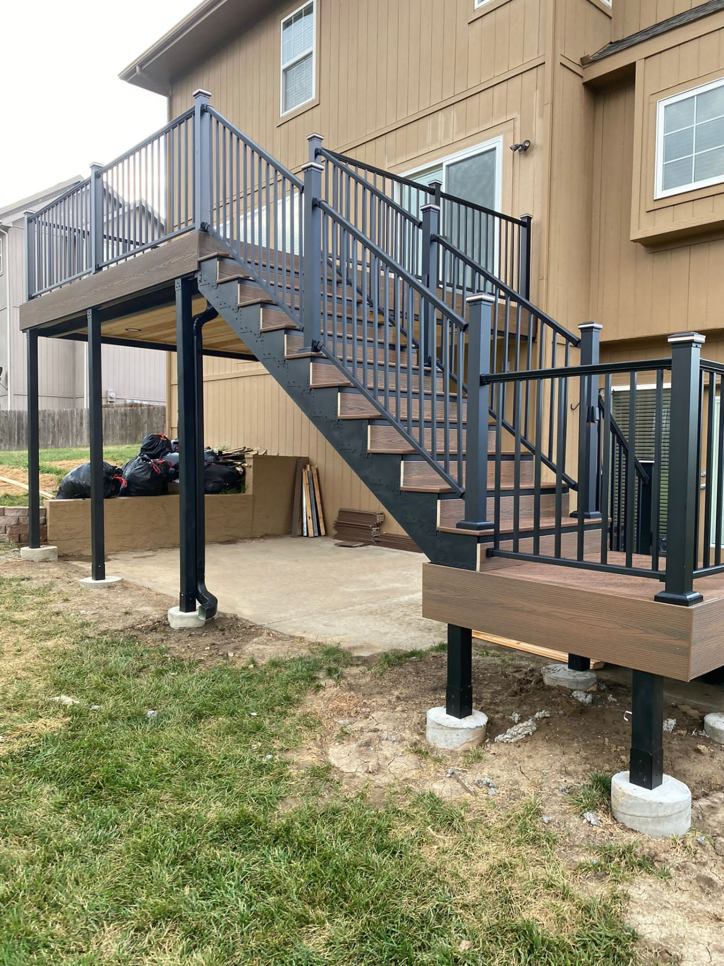 Elevated deck with steel stair stringers and black aluminum railing