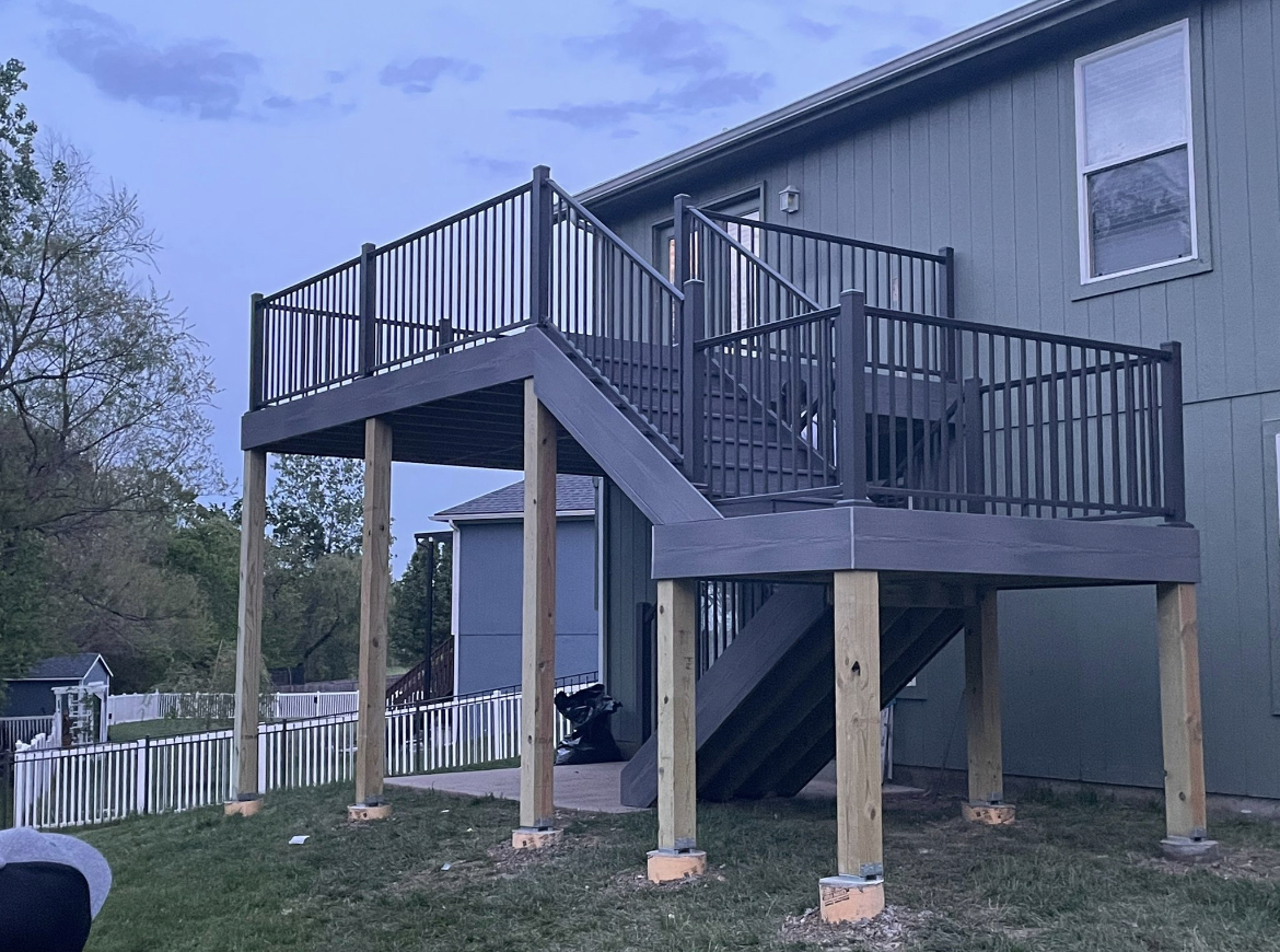 Elevated composite deck at dusk with matching gray railing and stairs