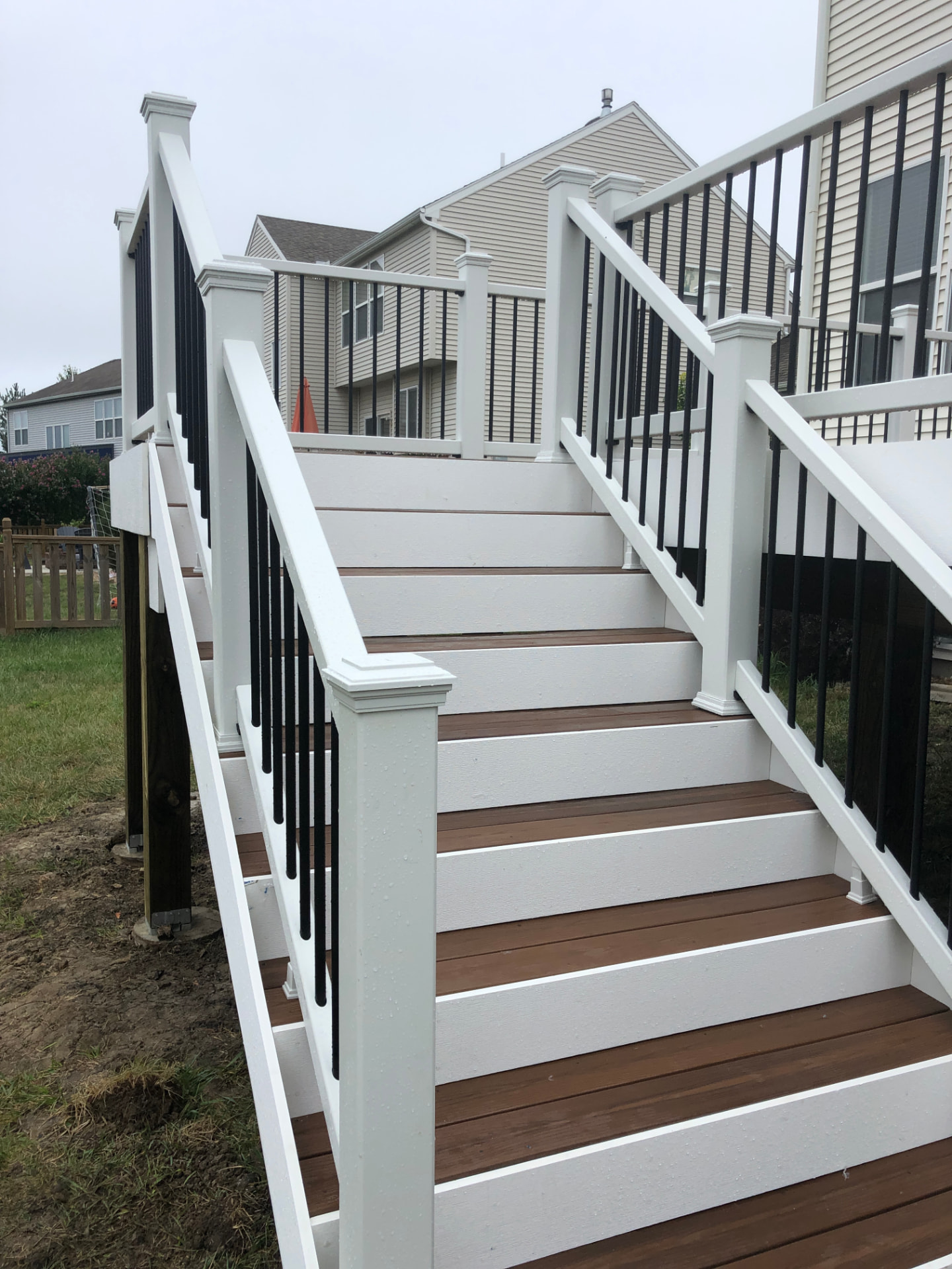 Composite deck stairs with white railing and black balusters
