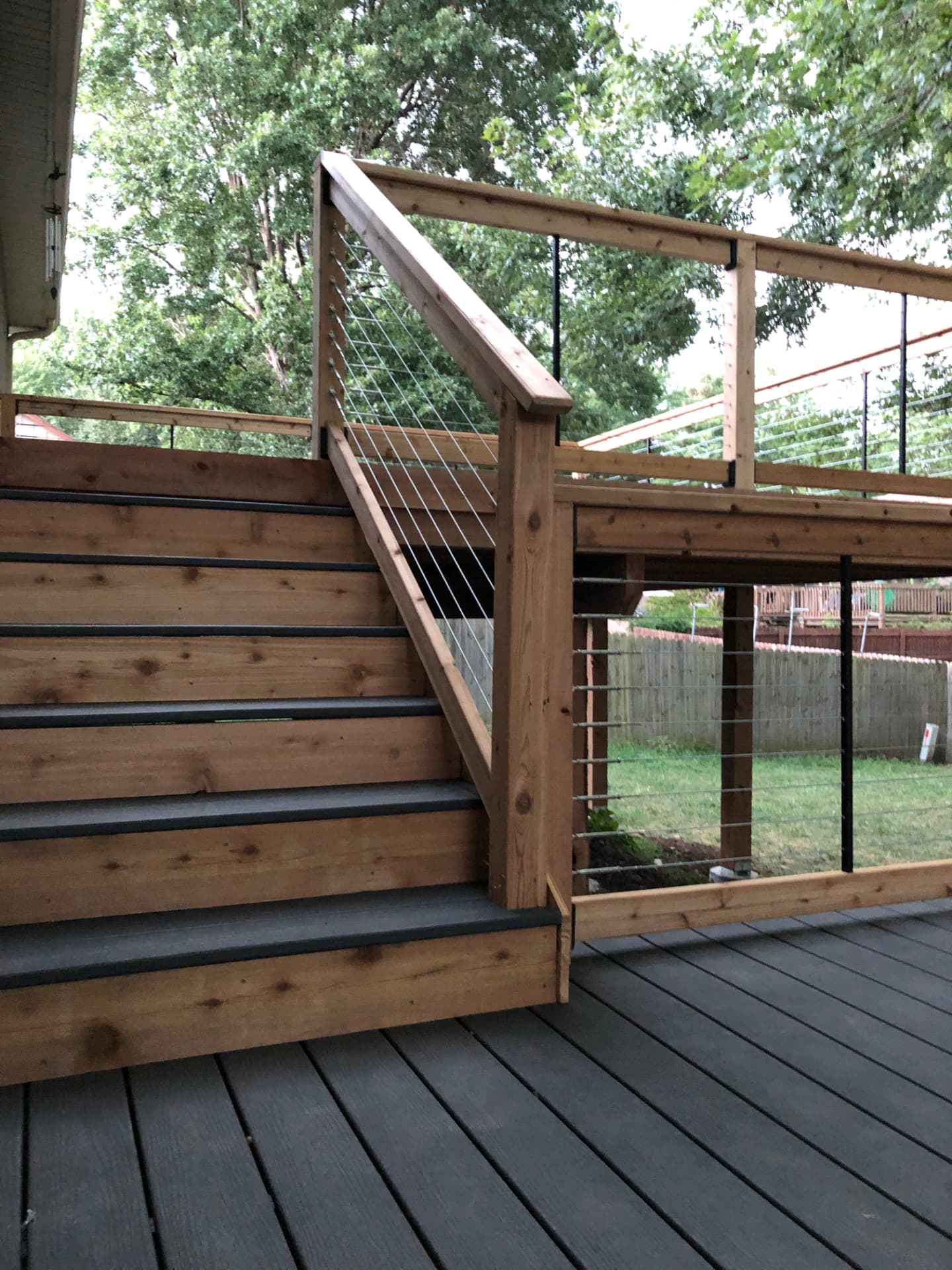 Cedar deck stairs with cable railing and gray composite decking