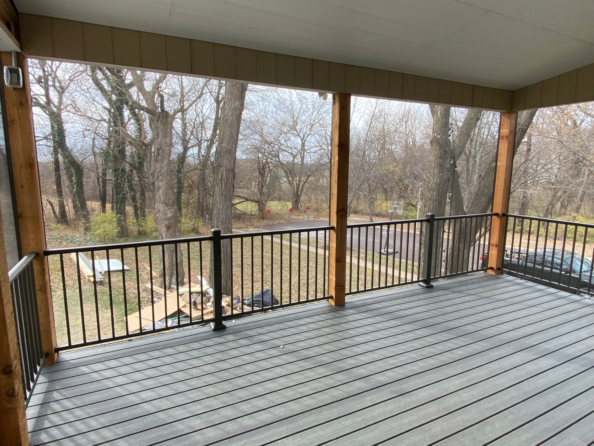 Covered porch with cedar posts, gray composite decking and black railing