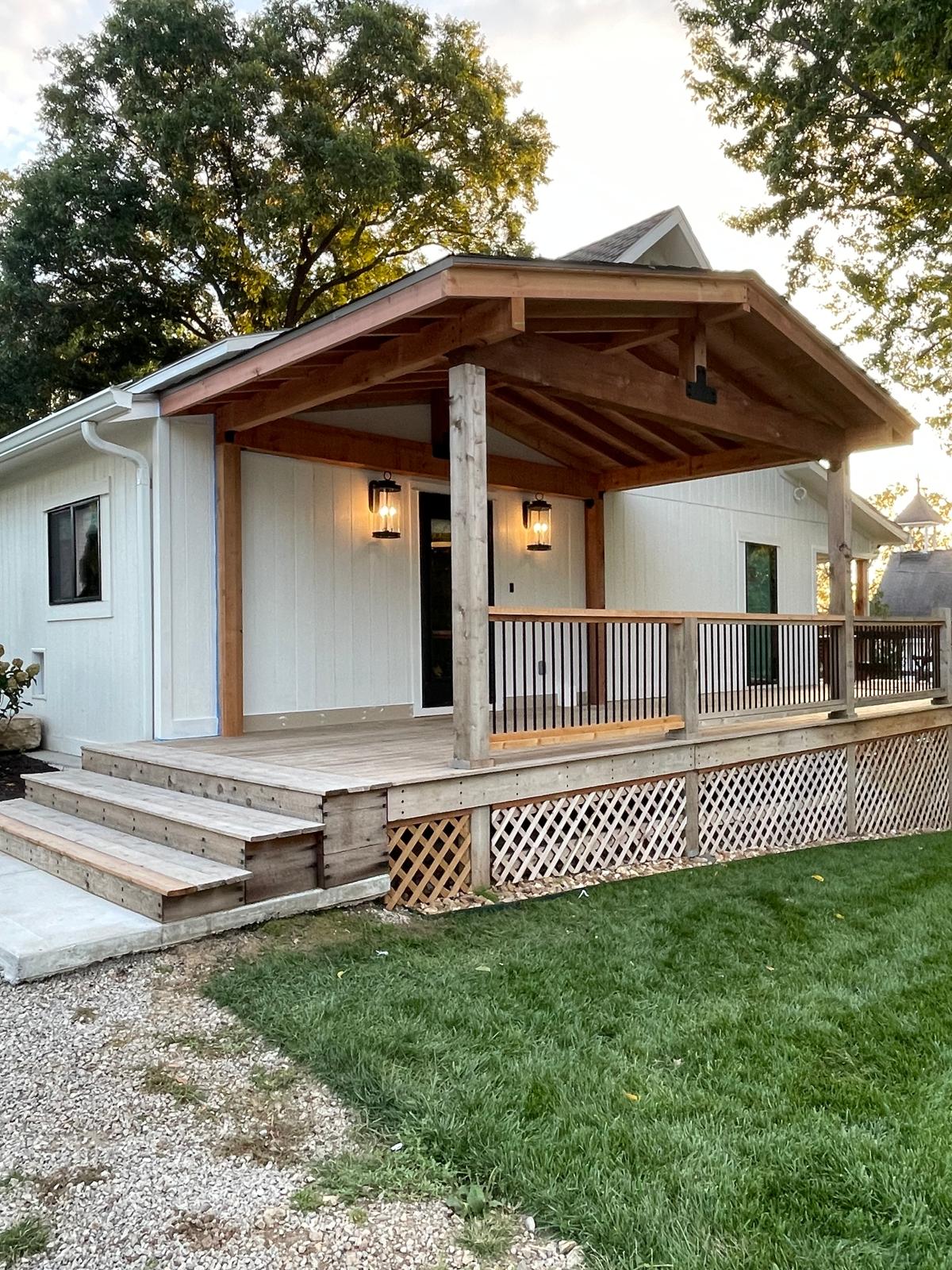 Cedar timber-frame covered front porch with lanterns and wood decking