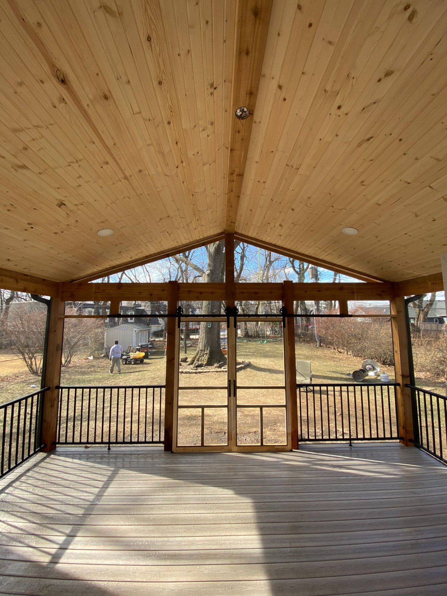 Screened porch with vaulted cedar ceiling and sliding screen doors